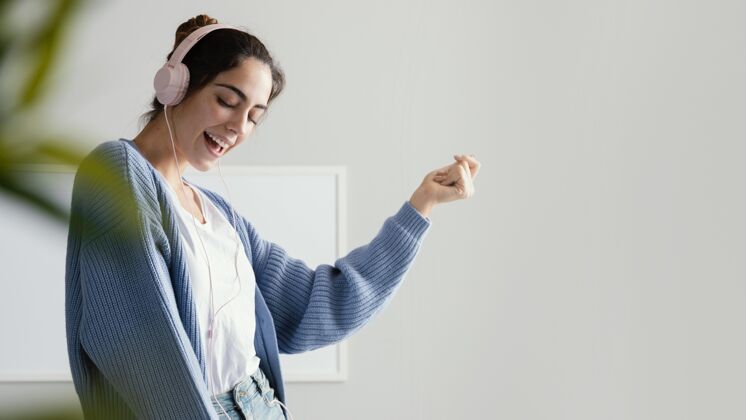 度假笑脸女人用耳机听音乐有复制空间家庭休闲休息时间