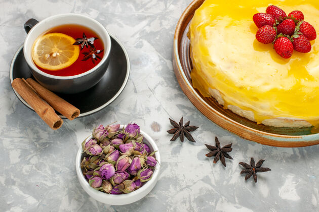 盘子俯瞰美味的水果蛋糕加黄色糖浆和一杯茶在白色表面蛋糕饼干甜甜的糖烤茶饼干顶部饼干糖浆