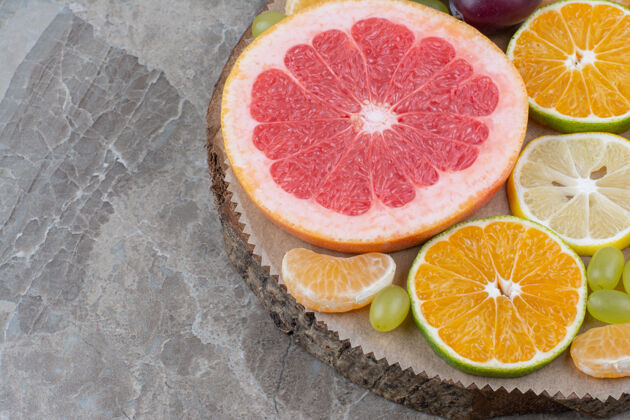 水果柑橘类水果片和葡萄放在木片上柚子美味天然