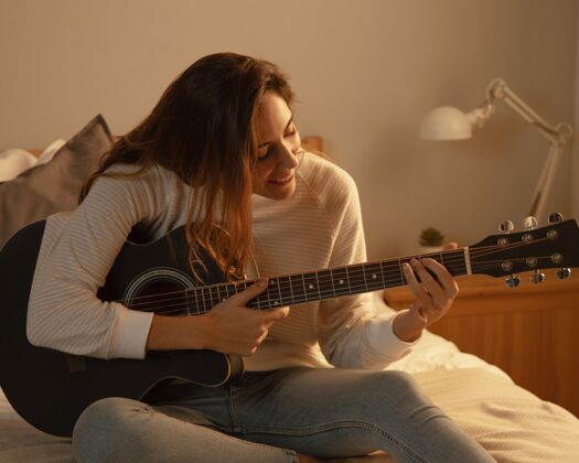 休假在家里床上弹吉他的女人住宿逗留娱乐