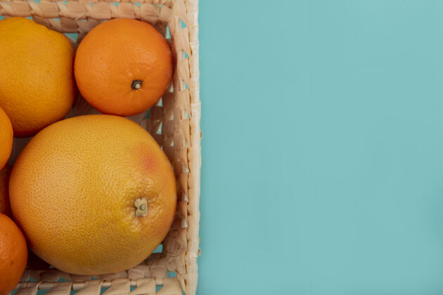 彩色顶视图复制空间橙子和葡萄柚在蓝绿色的背景篮子葡萄柚视图空间