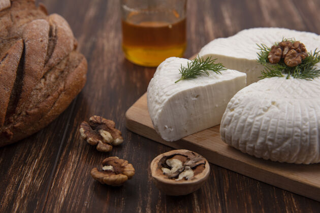 面包侧视图布林扎奶酪与核桃和面包在木制背景上的立场奶酪风景木头