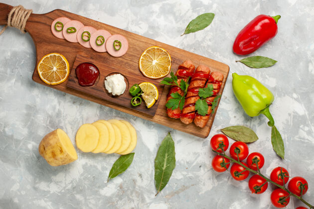 景观顶视图不同的食物组成香肠与新鲜西红柿和柠檬上的浅白色桌上餐食品veegtable彩色照片盘子午餐用餐