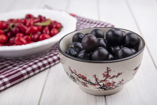 盘子侧视图樱桃李子放在碗里 山茱萸放在盘子里水果壁板食物