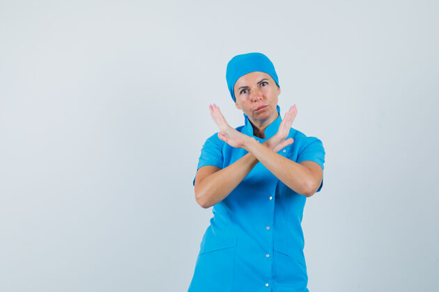 拒绝身穿蓝色制服的女医生 摆出拒绝的姿态 表情严肃 正前方病人肖像展示