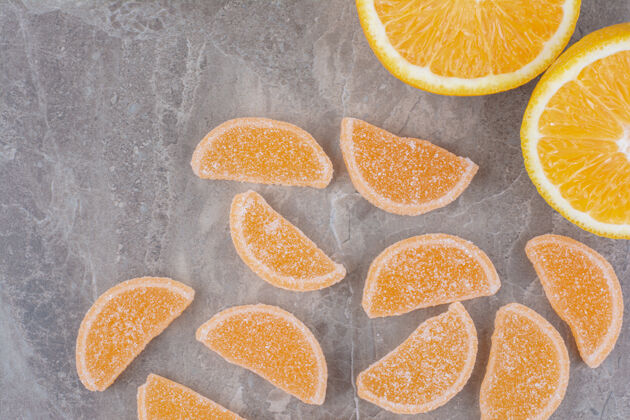 果冻新鲜的橘子片和甜甜的果酱放在大理石背景上柑橘橘子美味