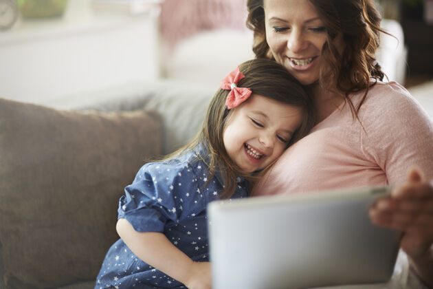 欢乐母女俩在平板电脑上看视频明亮触摸板可爱