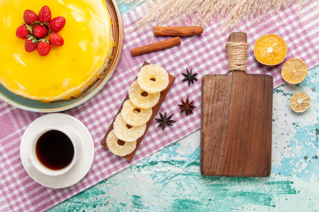 顶部俯瞰美味的黄色糖浆蛋糕和一杯茶蓝色表面饼干蛋糕甜饼饼干糖茶曲奇饼碗早餐