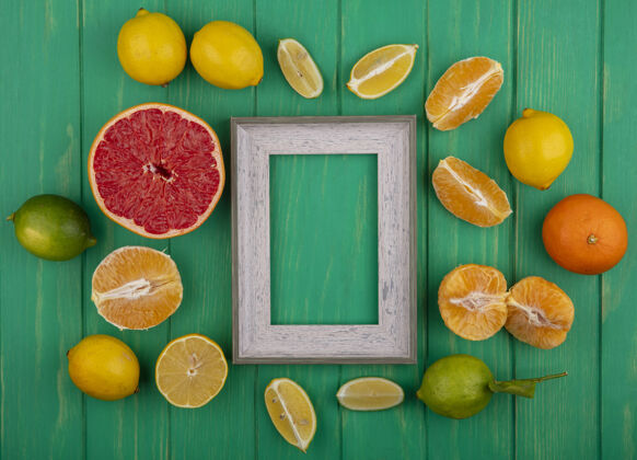 顶部顶视图复制空间灰色框架与去皮橙子和柠檬酸橙和半葡萄柚片绿色背景切片墙壁空间