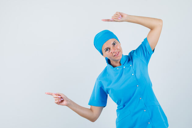 妇女女医生指着身穿蓝色制服的一侧 看上去很活泼正视图实验室护士治疗