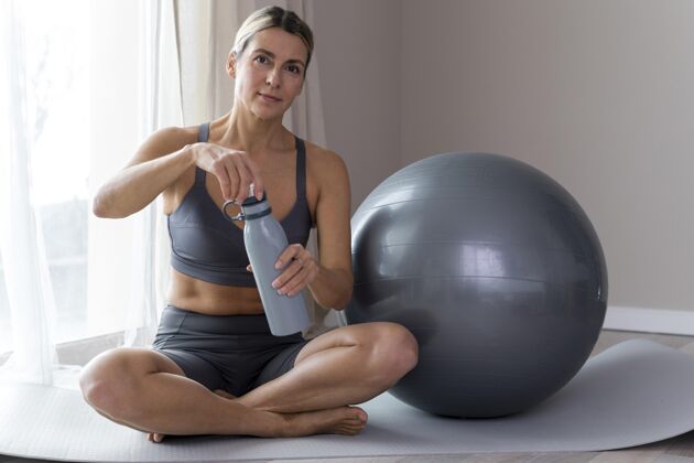 有氧穿着蓝色健身服的运动型女人打开瓶子私人教练健康活跃