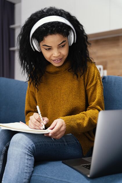知识笑脸少女与耳机和笔记本电脑在网上上学笔记本电脑学习课程