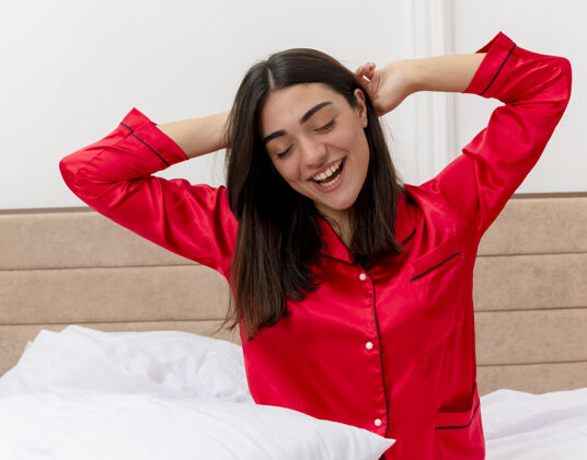 睡衣穿着红色睡衣在床上放松的年轻美女卧室伸展积极