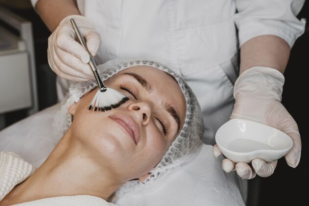 美容师年轻漂亮的女人在健康中心接受面部皮肤治疗护理面部健康