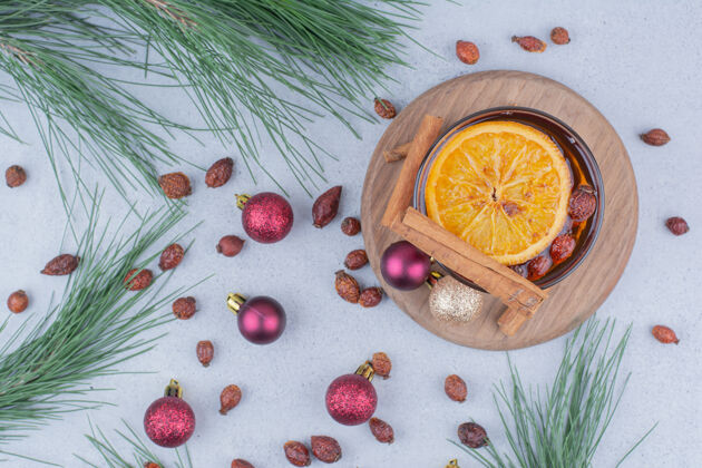 肉桂玫瑰果和圣诞球放在大理石表面的茶棍子圣诞饰品节日