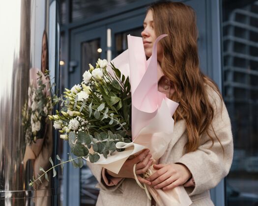开花户外时尚女士手持一束鲜花的正面视图户外春天花束