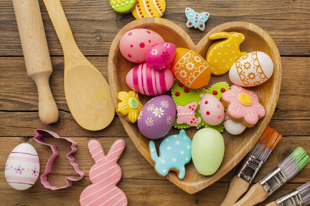 鸡蛋顶视图彩色复活节彩蛋在心形板与厨房用具和油漆刷复活节水平静物