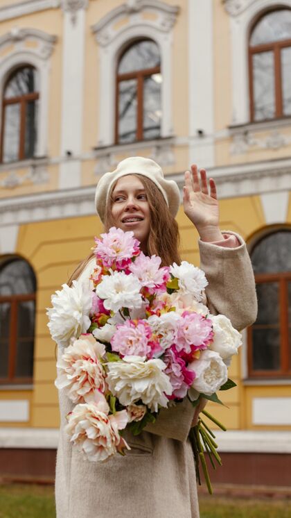 开花春天 优雅的女人在户外捧着一束鲜花城市花束春天