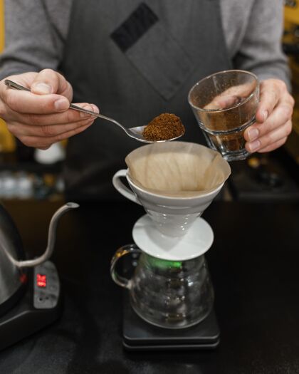 工作男咖啡师把咖啡放进过滤器里工作服务员服务员