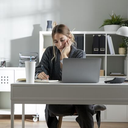 女性中等身材的女人在办公桌旁工作商业女性技术笔记本电脑