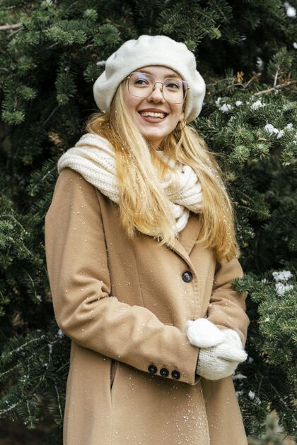 户外时髦的女人在冬天的公园里摆姿势业余爱好手套季节