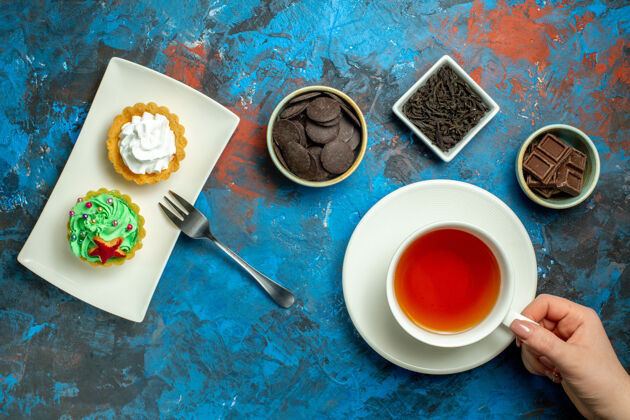 盘子俯瞰一杯茶小蛋糕巧克力蓝红色表面巧克力茶杯营养品