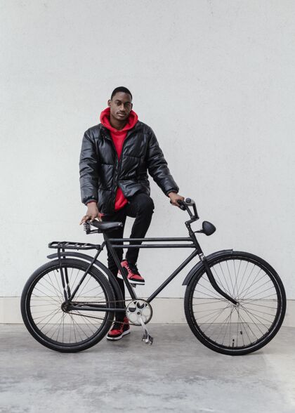 城市一个非裔美国人把他的自行车放在他面前户外骑街道