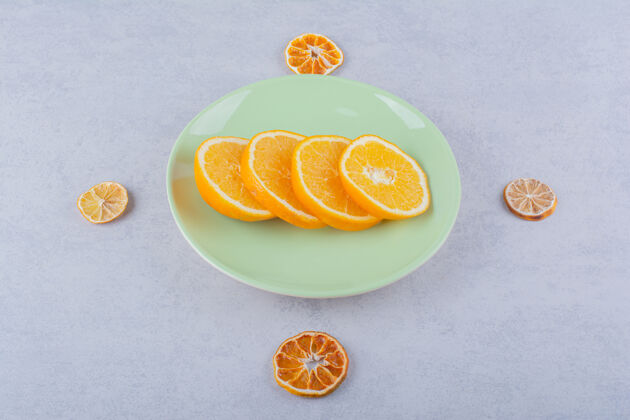 热带石桌上放着一盘鲜橙片柑橘健康多汁