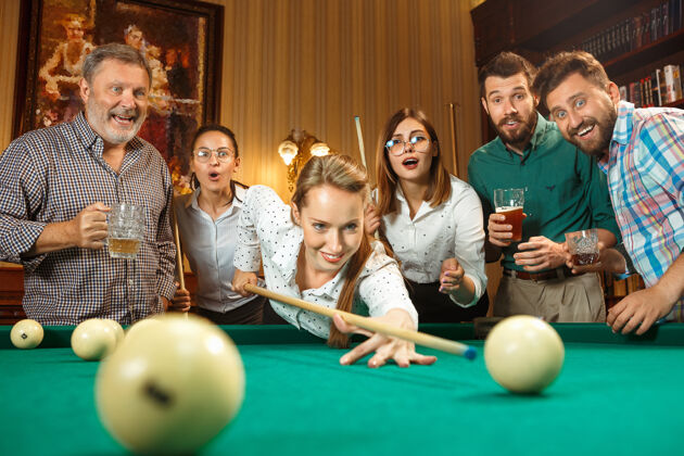 啤酒工作之余在办公室或家里打台球的年轻男女玩一起休闲