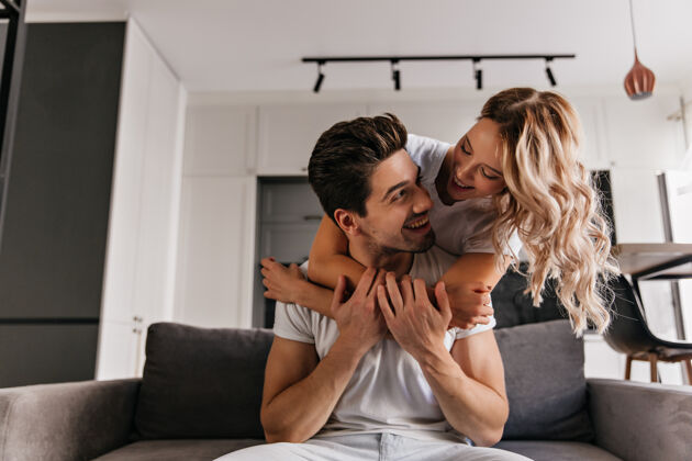 爱情迷人的白种女人用爱拥抱着丈夫令人惊奇的夫妇在周末玩得很开心的室内写真沙发公寓关系