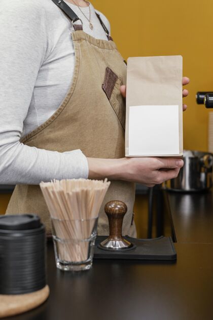 职业女咖啡师手持纸咖啡袋的侧视图女咖啡师工作