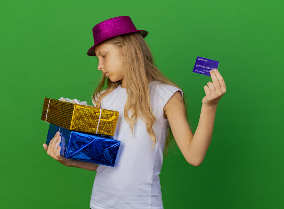 女孩戴着节日帽子拿着礼品盒的漂亮小女孩绿色帽子卡片
