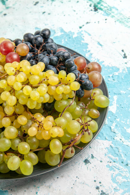 果汁前视图新鲜的彩色葡萄多汁和醇厚的浅蓝色表面水果水果生的多汁