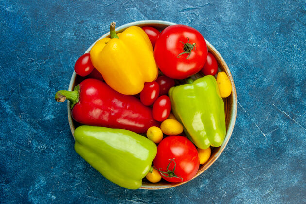 胡椒顶视图蔬菜不同颜色的甜椒西红柿樱桃西红柿在碗里蓝色的桌子上有复制空间甜椒餐桌甜味