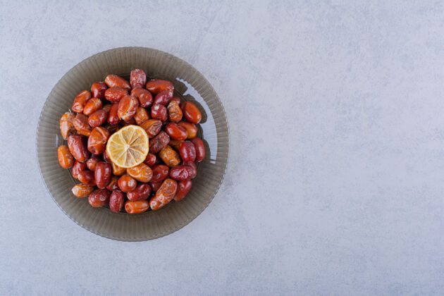 食品石头桌上摆着一盘深色的美味成熟的银莓素食水果健康