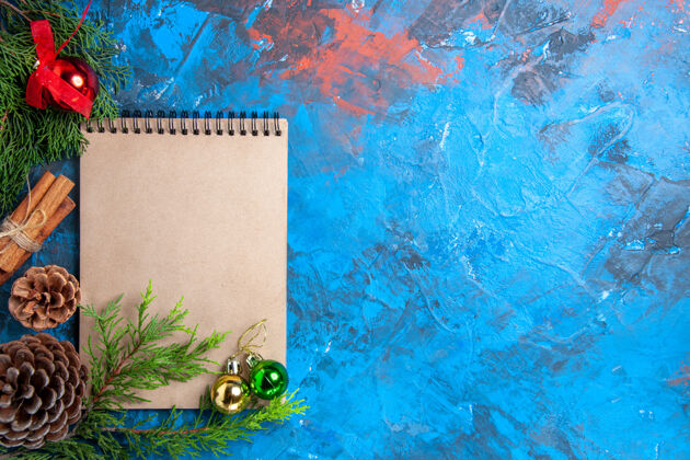 松果俯视圣诞树球笔记本上的松树树枝上的松锥蓝色表面自由空间视图顶树枝
