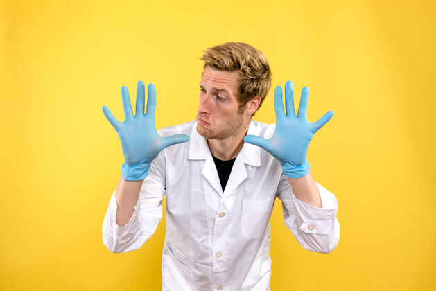 医院正面图黄色背景上戴着手套的男医生-医疗卫生医生手套男性