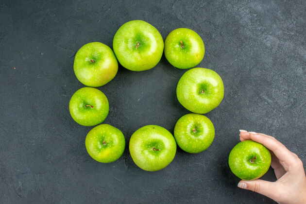 钥匙顶视图圆排青苹果在女人手里的黑桌子上健康绿色绿色苹果