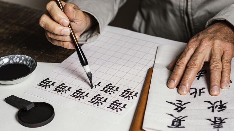中国水墨高角度的人在白纸上写中国符号书法水墨书法