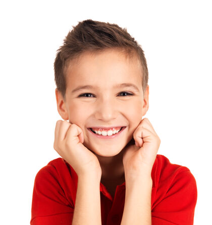 幼儿园一个可爱的快乐男孩的肖像 带着美丽的微笑照片在白墙上可爱小小学生