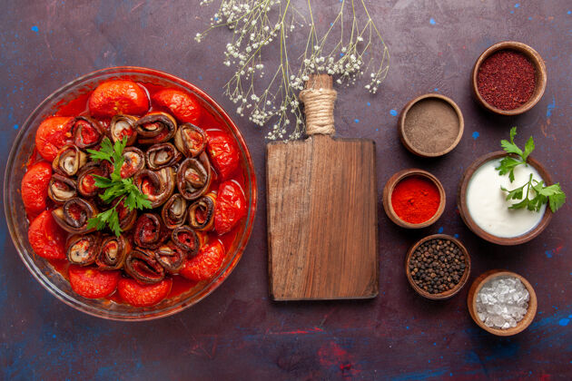 菜肴俯瞰煮熟的蔬菜餐美味的西红柿和茄子与调味品在黑暗的表面茄子番茄调味料
