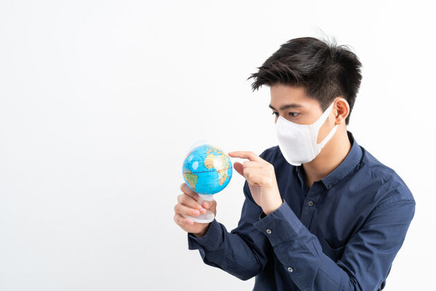 病毒戴着面具的亚洲人手里拿着世界地图地图亚洲人隔离