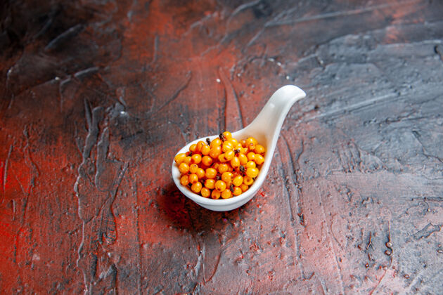 碗顶视图沙棘在白色碗在暗红色的桌子与复制空间果仁蔬菜沙棘
