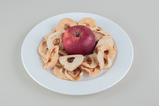 甜一个白色的盘子里装满了干苹果和一个完整的苹果收获甜点薯条