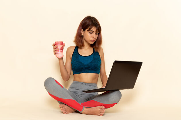 笔记本电脑年轻女性穿着蓝色衬衫 在白色墙上使用笔记本电脑 身体健康健康锻炼漂亮