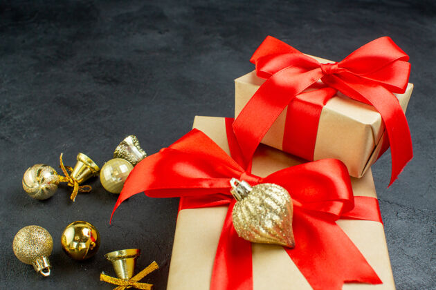 圣诞节礼品盒正面图 红色丝带和深色背景上的装饰配件风车弓机械