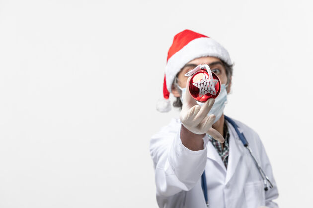 成人男医生手持新年树玩具健康病毒冠状病毒圣诞节微笑