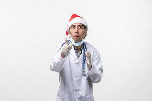 药品正面图男医生戴着手套对白墙病毒假日的情感圣诞节医生手套