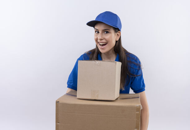 退出身穿蓝色制服 头戴鸭舌帽的年轻送货员拿着纸板箱 面带微笑地看着镜头 开心而兴奋女孩纸板看