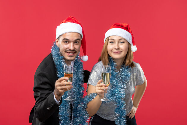 帽子前视图年轻夫妇刚刚庆祝新年在红地板党爱圣诞节肖像微笑年轻夫妇